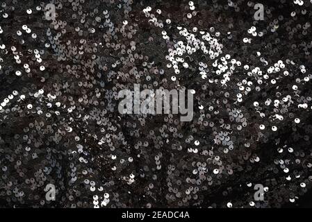 Shiny paillettes on black fabric piece Stock Photo