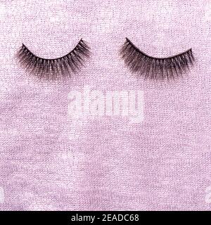 Fake eyelashes on knitted pink sweater Stock Photo