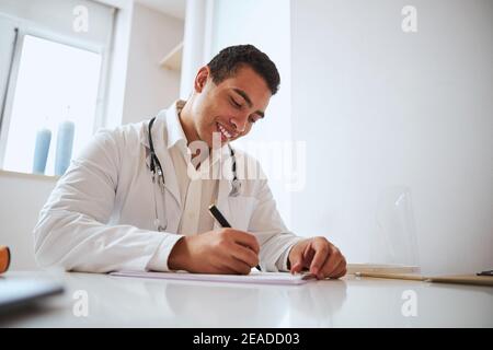 Professional Indian doctor working with documents in medicine office Stock Photo