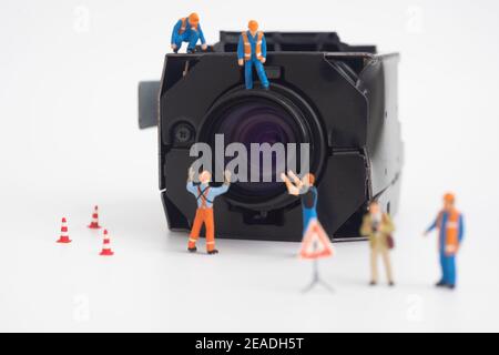 CCTV surveillance security camera with worker doing maintenance or installing. Stock Photo