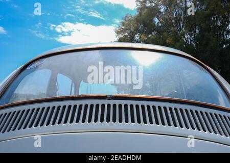 Old rusty volkswagen beetle window glass rear window on a bright sunny day Stock Photo