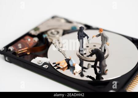 Hackers robbing computer. people in black masks stealing data with hardisk metaphore background. Concept of stealing confidential data documents from Stock Photo
