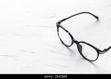 Eyeglasses with black frame on white background. Eye glasses. Round glasses with transparent lenses. Close up eyeglasses with blurry technique. Fashio Stock Photo