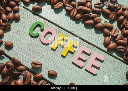 Coffee Day alphabets form on roasted coffee beans background. Stock Photo