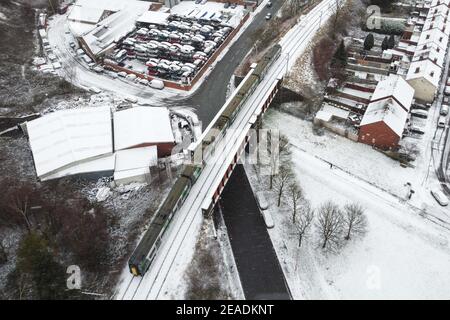 Birmingham, West Midlands, UK. 9th Feb, 2021. A train crosses a railway bridge in the Winson Green area of Birmingham as snow fell overnight as Storm Darcy continues it's wintry blast from the east. Pic by Credit: Sam Holiday/Alamy Live News Stock Photo