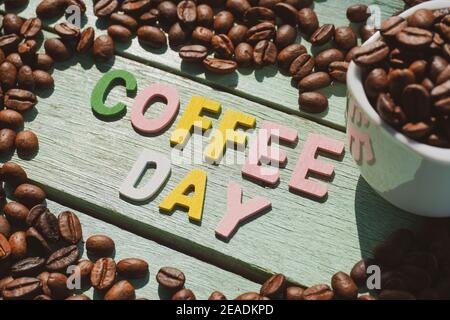 Coffee Day alphabets form on roasted coffee beans background. Stock Photo