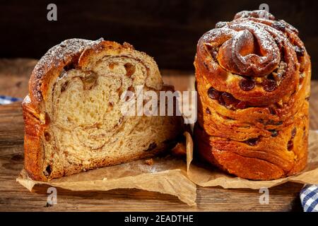 Easter cake kraffin. Kraffins with raisins, candied fruits and poppy seeds, sprinkled with powdered sugar. Close-up of homemade cake. Cruffin. Stock Photo