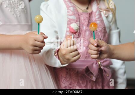 Children eating lollipops on a stick close up Stock Photo