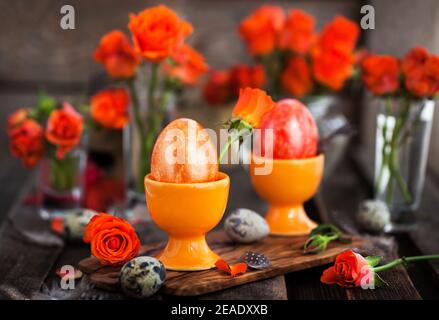 Easter colorful painted orange eggs and roses, spring holiday concept Stock Photo