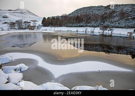 Holyrood Park, Edinburgh, Scotland, UK. 9th February 2021. Is it a bird, is it a plane?  Pictured: Dunsapie Loch with an interesting design on the surface left by the snow fall and water from the loch. Stock Photo