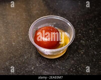 Close up of a Gulab Jamun in a small takeout cup. Stock Photo
