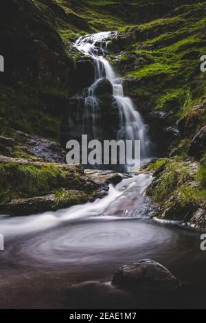 Lake District Waterfall Whirlpool slow shutter moving water rock and green moss moody Stock Photo