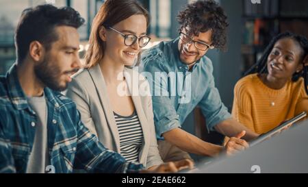 University Library: Diverse Group of Equally Gifted Students Have Discussion, use Laptop, Prepare for Exams Together, Helping, Researching Subjects Stock Photo
