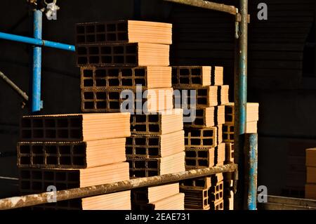 Hollow construction bricks stacked on a construction site on the scaffoldings (Pesaro, Italy, Europe) Stock Photo