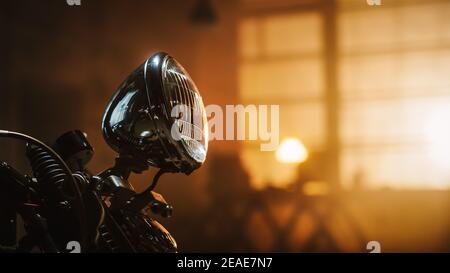 Close Up Details of a Custom Bobber Motorbike Standing in an Authentic Creative Workshop. Chromed Motorbike Headlight, Handle Bars and Shock Absorbers Stock Photo