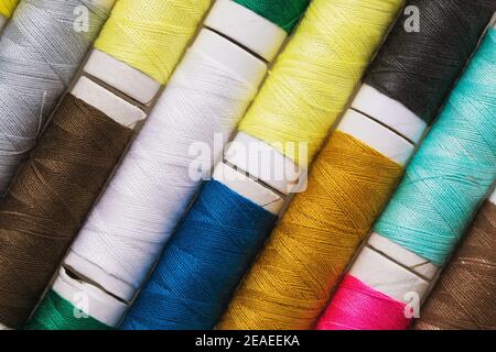 Texture from spools with multi-colored threads, top view, close-up. Stock Photo