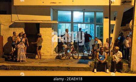 People lining-up in a pharmacy at night, Santa Clara, Cuba Stock Photo