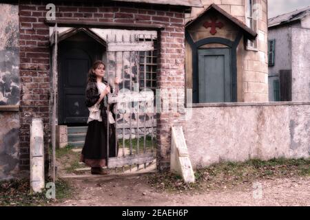 A woman parishioner at the wicket  of an ancient Church in the style of architecture of medieval Europe Stock Photo