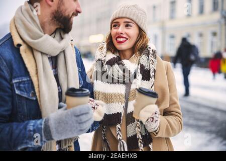 Happy couple having hot drinks in city centre Stock Photo