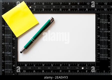 Note sticker, green pen and carpenter's square to personalize with the logo of your company over white background Stock Photo