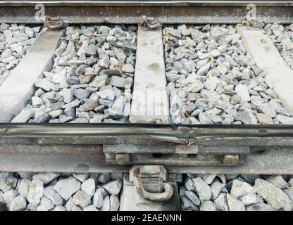 Broken railroad tracks at the inter-rail joints at risk of causing an accident, near the station in the city, front view with the copy space. Stock Photo