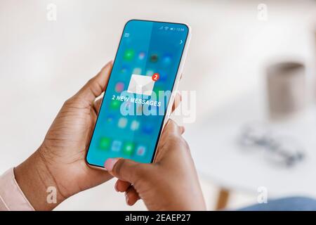 Black Woman Using Smartphone With New E-Mail Message In Office Stock Photo