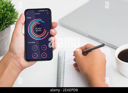 Data Analysis And Management Concept. Unrecognizable Woman Checking Activity Report On Smartphone Stock Photo