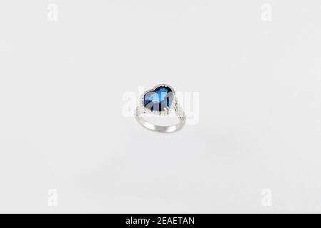 Heart shaped blue sapphire precious ring isolated on white background. White golden ring with blue gemstone. Jewelry, fashion jewellery theme. Stock Photo