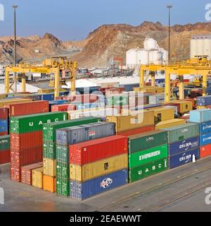 Aerial view commercial dock & colourful shipping containers below yellow mobile cranes at Port Sultan Qaboos Muttrah Muscat Gulf of Oman Middle East Stock Photo