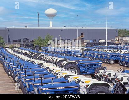 Historical archival 1990s view Ford tractor factory at Basildon storage compound completed iconic blue & white tractors water tower beyond  Essex UK Stock Photo
