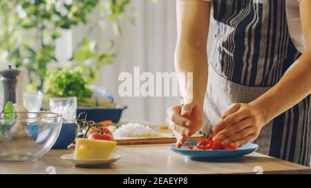 Close Up Shot of a Man Putting a Chopped Tomato in a Bowl. Preparing a Healthy Vegetarian Organic Salad Meal in a Modern Kitchen. Natural Clean Diet