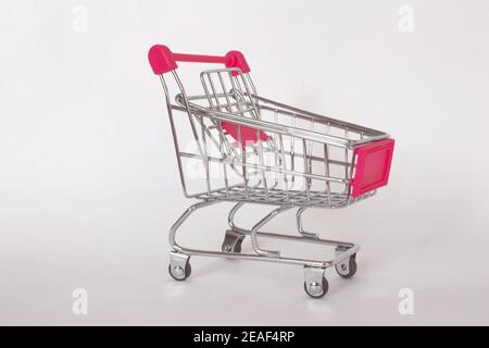 Empty small pink shopping trolley or cart isolated on white background. Shopping concept. Stock Photo