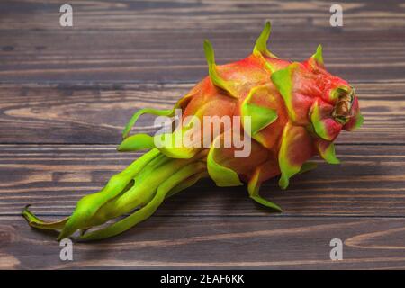 Red pitahaya. Ripe pitahaya fruit lies on a background of wooden boards. High quality photo Stock Photo