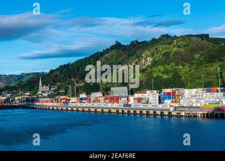 February 22, 3018--Shipping containers cover the docks at the beautiful town of Dunedin. A church is in the background. Stock Photo