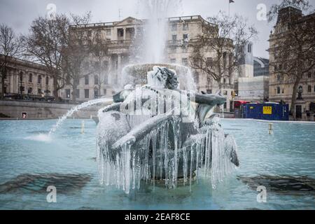 UK Weather: Storm Darcy: Icicles hang from the mermaid fountain statues in Trafalgar Square, London, UK. Stock Photo