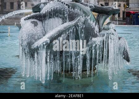 UK Weather: Storm Darcy: Icicles hang from the mermaid fountain statues in Trafalgar Square, London, UK. Stock Photo