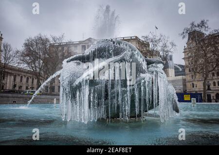 UK Weather: Storm Darcy: Icicles hang from the mermaid fountain statues in Trafalgar Square, London, UK. Stock Photo