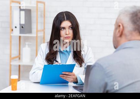 Senior man visiting doctor in modern office interior Stock Photo