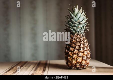 Whole pineapple fruit on the table. Copy space Stock Photo