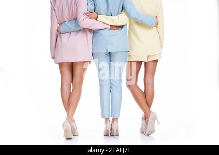 Three women in pastel suits posing over white background Stock Photo