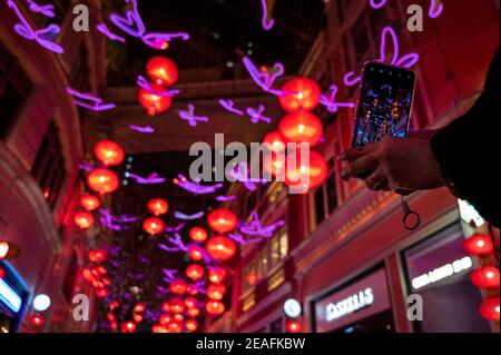 Hong Kong, China. 09th Feb, 2021. A woman uses her smartphone to take photos of hundreds of red lanterns hanged from the ceiling at Lee Tung Avenue in Hong Kong to celebrate the Chinese Lunar New Year festival and the year of the Ox. Credit: SOPA Images Limited/Alamy Live News Stock Photo
