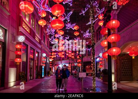 Hong Kong, China. 09th Feb, 2021. A couple wearing masks walks under hundreds of red lanterns hanged from the ceiling at Lee Tung Avenue in Hong Kong to celebrate the Chinese Lunar New Year festival and the year of the Ox. Credit: SOPA Images Limited/Alamy Live News Stock Photo