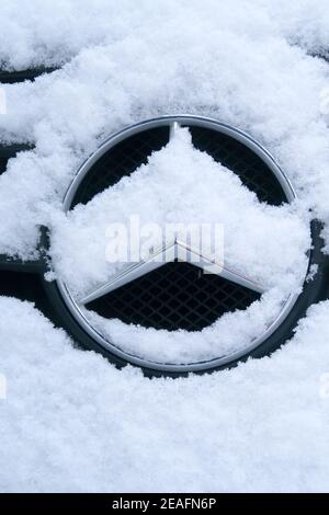 The Mercedes-Benz logo covered in snow Stock Photo