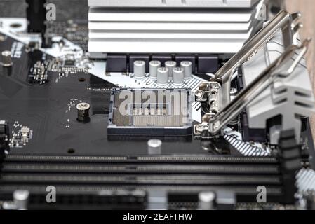 Macro shot of empty modern LGA 1200 socket for CPU on black desktop motherboard. Stock Photo