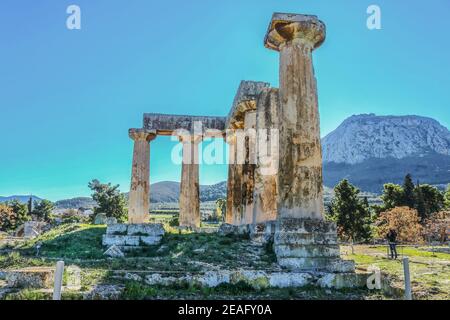 Columns in ruins of Temple of Apollo with Acrocorinth the acropolis of ancient Corinth - a monolithic rock overseeing the ancient city of Corinth Gree Stock Photo