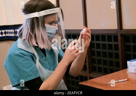 London UK - 07 Feb 2021: a NHS nurse drawing the vaccine in the newly converted Covid-19 vaccination centre Al-Manaar in London. Stock Photo