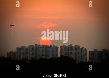 Beautiful view of sunset behind the high rise buildings along the east coast road, chennai, India. Selective focus Stock Photo