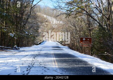Footprints in the ice and snow coating the road on a section of the Blue Ridge Parkway closed to cars for the winter near Asheville, North Carolina Stock Photo