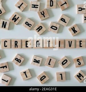 The word creative spelled out in wooden craft letters surrounded by letters.  Concept business, innovation, and ideas. Stock Photo