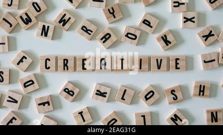 The word creative spelled out in wooden craft letters surrounded by letters.  Concept business, innovation, and ideas. Stock Photo
